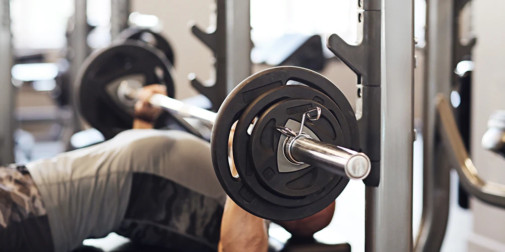 a man doing bench presses in a commercial gym