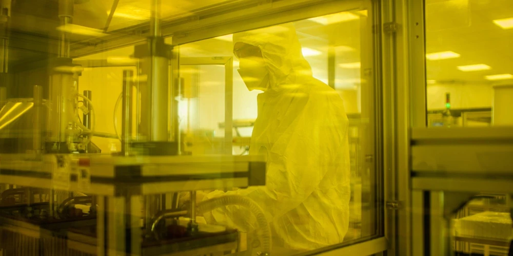 a worker in sterilize dress in a cleanroom with amber light